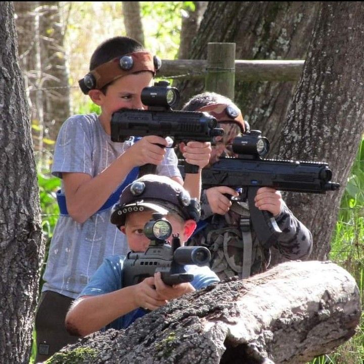 A kids team crouched behind a log