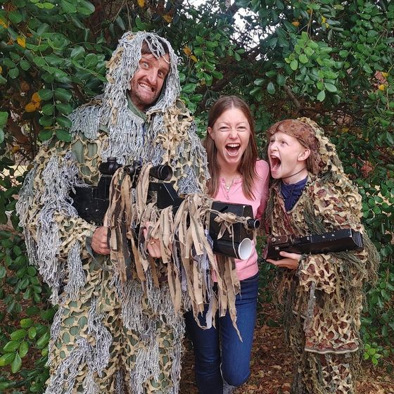 Three players in ghillie suits laughing