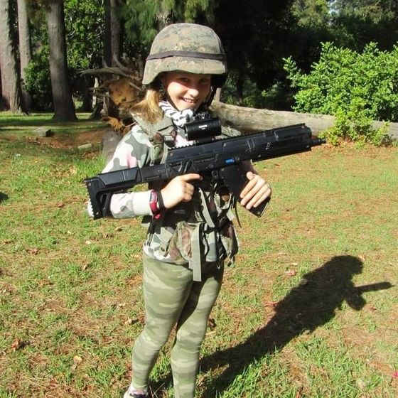 A kid in a helmet stands guard