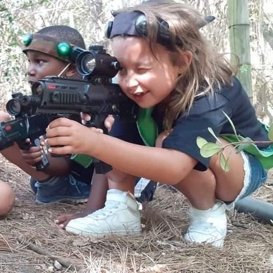 Two kids in headbands aim together