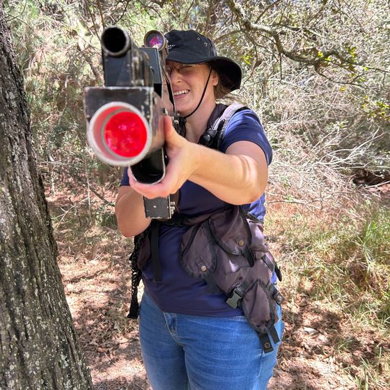 A player aims a gun with a red lens